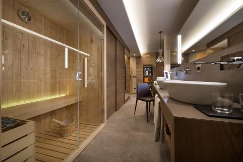 a bathroom with a sink and a glass wall at Hotel Baita Montana in Livigno