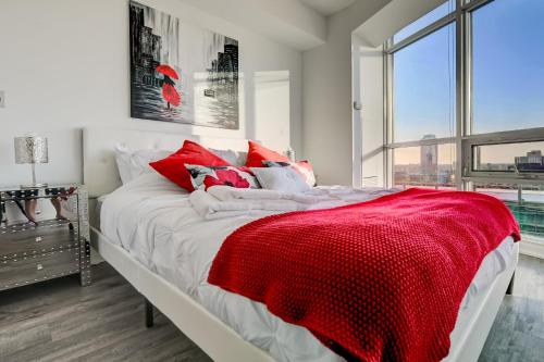 1 dormitorio con 1 cama grande con manta roja en Specious LUX 2BD Downtown Toronto with Parking! en Toronto
