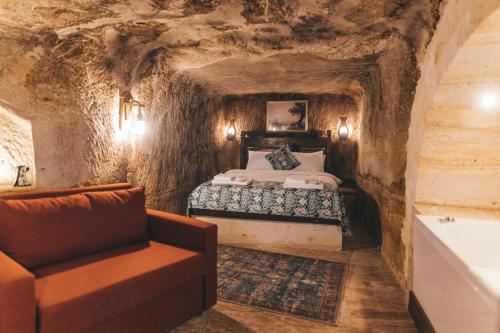 於爾居普的住宿－Tale Cave İnn，洞穴内的卧室,配有床和沙发