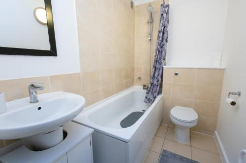 a bathroom with a sink and a tub and a toilet at Must See One Bed Leicester City Centre Apartment in Leicester