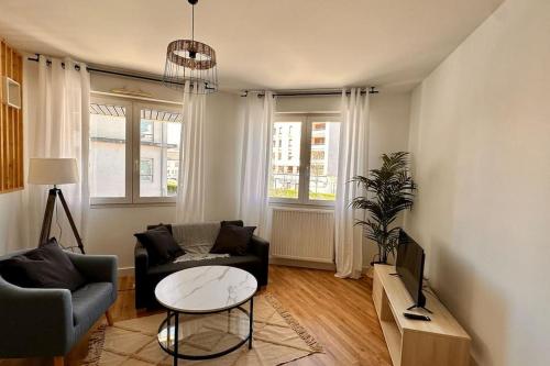 een woonkamer met een bank en een tafel bij Villeurbanne • T2 Fraternité • HostisY in Villeurbanne