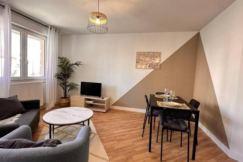 een woonkamer met een bank en een tafel met stoelen bij Villeurbanne • T2 Fraternité • HostisY in Villeurbanne