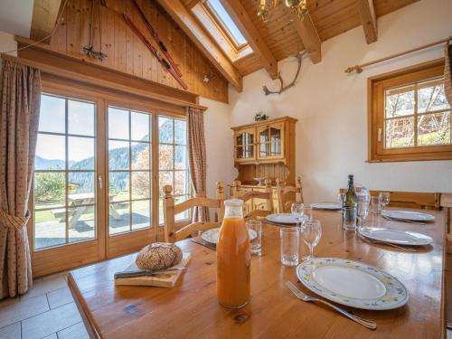 comedor con mesa de madera y ventana grande en Chalet Six des Armailles by Interhome, en Ovronnaz