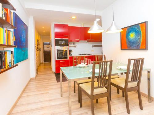 a kitchen with red cabinets and a table and chairs at Apartment Eixample Dret Independencia Valenci by Interhome in Barcelona