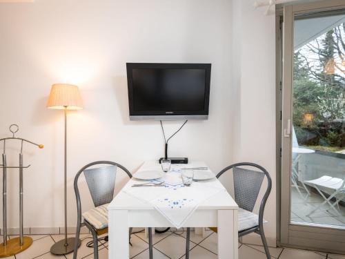 mesa blanca con sillas y TV en la pared en Apartment An der Mosel by Interhome, en Traben-Trarbach