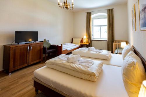 ein Hotelzimmer mit 2 Betten und einem Flachbild-TV in der Unterkunft Hotel Schyrenhof in Scheyern
