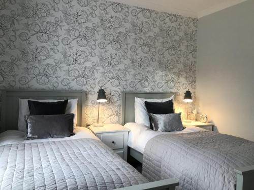 two beds sitting next to each other in a bedroom at The Glastonbury Townhouse B&B in Glastonbury