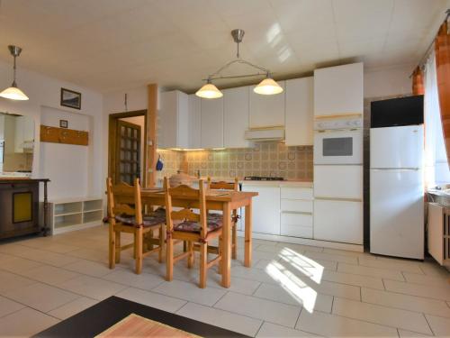 a kitchen with a wooden table and chairs in it at Apartment Santa Lucia-3 by Interhome in Valdisotto