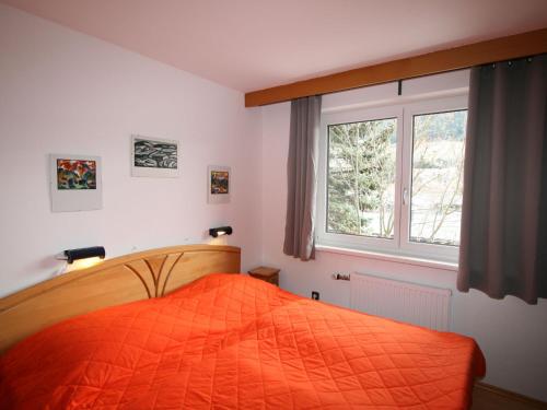 ein Schlafzimmer mit einem orangenen Bett und einem Fenster in der Unterkunft Apartment Biegel-Kraus by Interhome in Steinach am Brenner