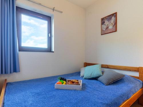 a bedroom with a bed with a tray of fruit on it at Apartment Les Mousquetons-20 by Interhome in La Toussuire