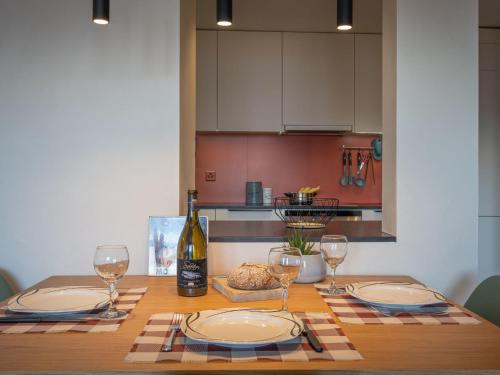 a wooden table with plates and wine glasses on it at Apartment Plein Soleil A 9 by Interhome in Ovronnaz