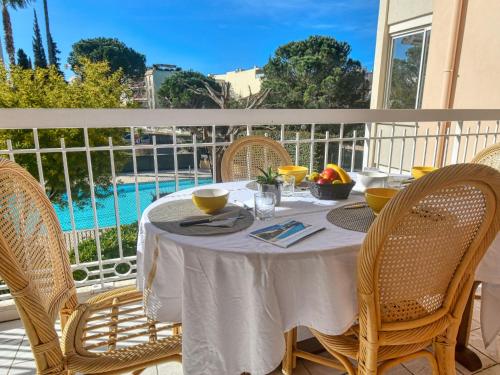 聖拉斐爾的住宿－萊斯加爾丁伊甸公寓，一个带泳池的阳台,配有一张带椅子的白色桌子