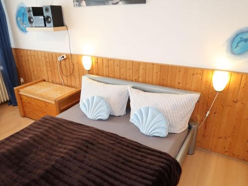 um quarto com uma cama com duas almofadas em Apartment Rosengrund by Interhome em Büsum