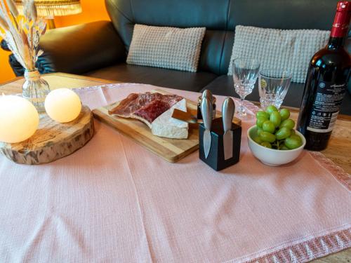 ein Tisch mit einem Teller Fleisch und einer Flasche Wein in der Unterkunft Apartment Schonerweg by Interhome in Norddeich