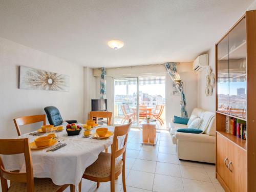 uma sala de jantar com mesa e cadeiras e uma sala de estar em Apartment L'Aétius by Interhome em Fréjus