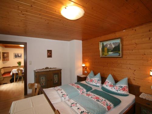 een slaapkamer met een bed met blauwe kussens bij Apartment Neumann - FBZ202 by Interhome in Finkenberg