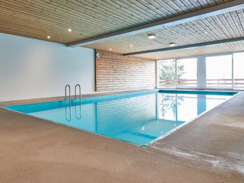 a swimming pool in a building with an indoor swimming pool at Studio Hammeau D003 by Interhome in Les Collons