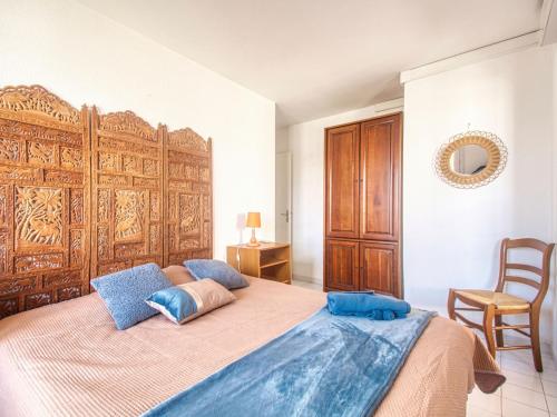 een slaapkamer met een groot bed met een houten hoofdeinde bij Apartment Bleu Marine-6 by Interhome in Fréjus