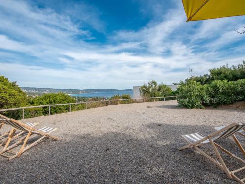 un patio avec deux chaises et un parasol dans l'établissement Apartment Les Arbousiers-1 by Interhome, à Cavalaire-sur-Mer