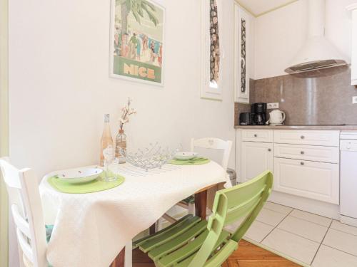 une salle à manger avec une table et des chaises vertes dans l'établissement Apartment France by Interhome, à Nice