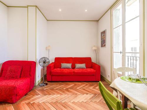 - un canapé rouge et une chaise dans le salon dans l'établissement Apartment France by Interhome, à Nice