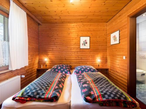 1 dormitorio con 2 camas en una habitación con paredes de madera en Apartment Reinskopf-1 by Interhome en Schönecken