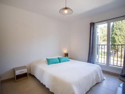 une chambre avec un lit et une grande fenêtre dans l'établissement Apartment Le Clos Jardin-1 by Interhome, à Bormes-les-Mimosas