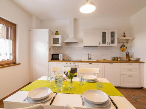 a kitchen with a table and chairs and a kitchen with white cabinets at Holiday Home Casa di Nonno by Interhome in Cividale del Friuli