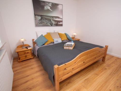 een slaapkamer met een groot houten bed en 2 nachtkastjes bij Apartment Nordstrand by Interhome in Norddeich