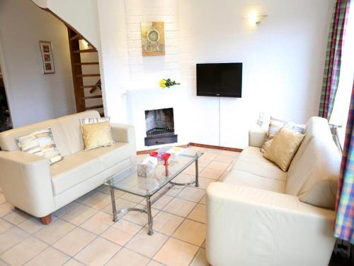 a living room with two white couches and a fireplace at Holiday Home Bungalowpark Landsrade by Interhome in Gulpen