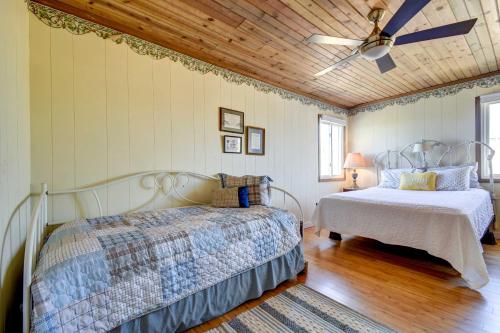 a bedroom with two beds and a ceiling fan at Ocean Isle Beach Home with Canal Views! in Ocean Isle Beach