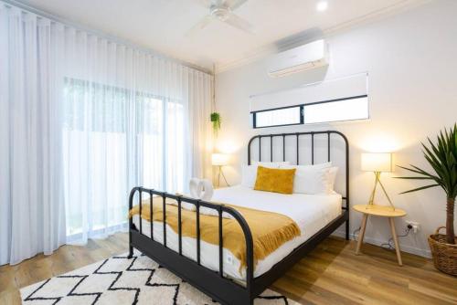 a bedroom with a bed with a black frame and yellow sheets at Industrial Luxe Villa - Boutique 1 bedroom luxury Villa in Edge Hill