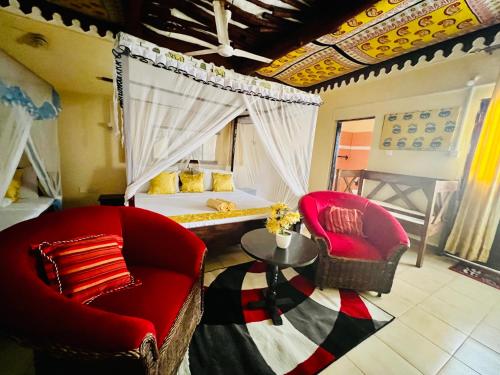sypialnia z łóżkiem, 2 krzesłami i stołem w obiekcie Lovely 5-Bed Room House With a swimming Pool w mieście Diani Beach
