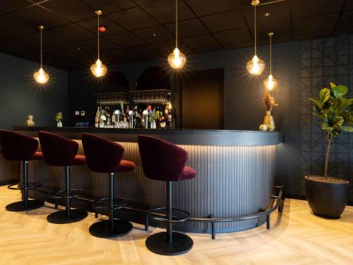 a bar with red stools in a room at Holiday Home Citta Romana-1 by Interhome in Hellevoetsluis