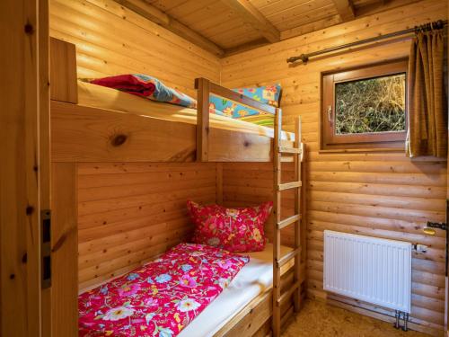 a bedroom with bunk beds in a wooden cabin at Holiday Home Reinskopf-3 by Interhome in Schönecken