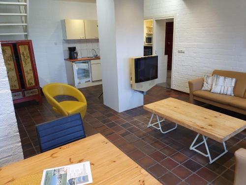 ein Wohnzimmer mit einem Sofa und einem Tisch in der Unterkunft Holiday Home Bungalowpark Landsrade by Interhome in Gulpen-Wittem