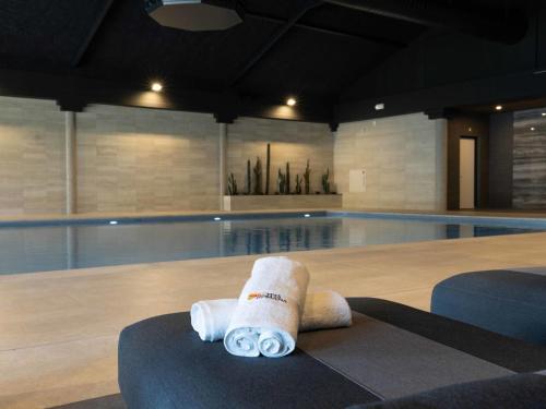 a stack of rolled towels next to a swimming pool at Holiday Home Citta Romana-1 by Interhome in Hellevoetsluis