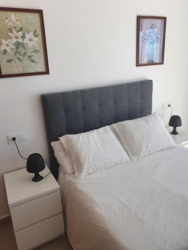 a bed with a blue headboard in a bedroom at Apartment Mojon Hills in Isla Plana