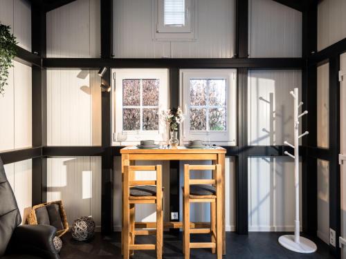 Pokój z drewnianym stołem i 2 oknami w obiekcie Holiday Home Tiny Haus Westerwald 16 Green by Interhome w mieście Bad Marienberg