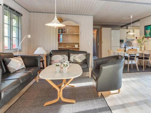 a living room with a couch and a table at Holiday Home Elona - 950m from the sea in Bornholm by Interhome in Vester Sømarken