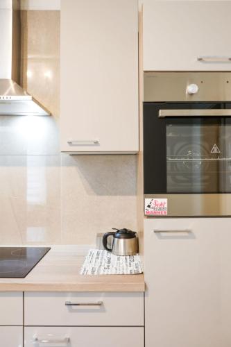 a kitchen with white cabinets and a pot on a counter at Apartment Am Ostedeich-2 by Interhome in Oberndorf