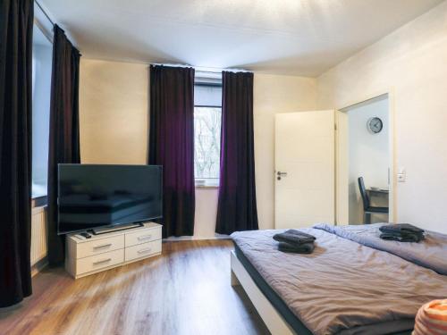 a bedroom with two beds and a flat screen tv at Apartment Am Ostedeich-2 by Interhome in Oberndorf