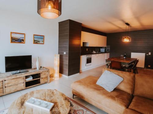 a large living room with a couch and a table at Apartment The Horseshoe with parking by Interhome in Bredene