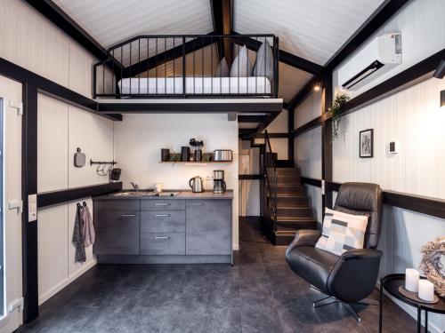 uma cozinha e sala de estar com um loft em Holiday Home Tiny Haus Westerwald 16 Blue by Interhome em Bad Marienberg