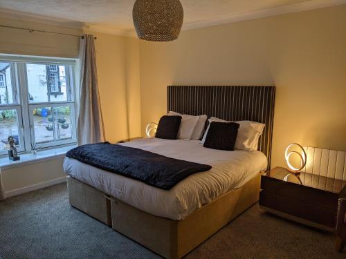 Un dormitorio con una cama grande y una ventana en sorn inn holiday apartments, en Sorn
