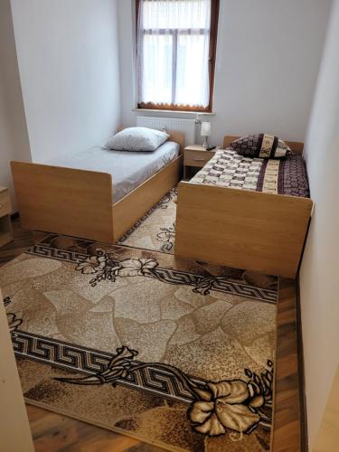 a bedroom with two beds and a rug at 3 Zimmer Wohnung für 6 Personen in Gößnitz