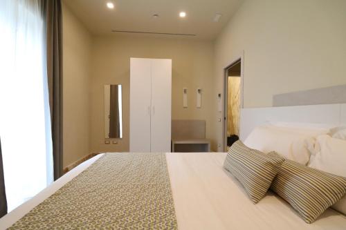 ein Schlafzimmer mit einem großen weißen Bett mit zwei Kissen in der Unterkunft Doride Suites Boutique Hotel in Marina di Carrara