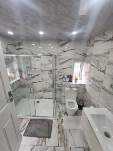 a bathroom with a shower and a toilet and a sink at Lovely 2-bedroom house close to Media City. in Manchester