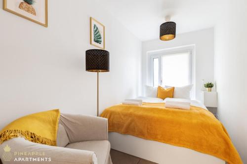 a bedroom with a bed with a yellow blanket on it at Pineapple Apartments Dresden Zwinger VI - 98 qm - 1x free parking in Dresden
