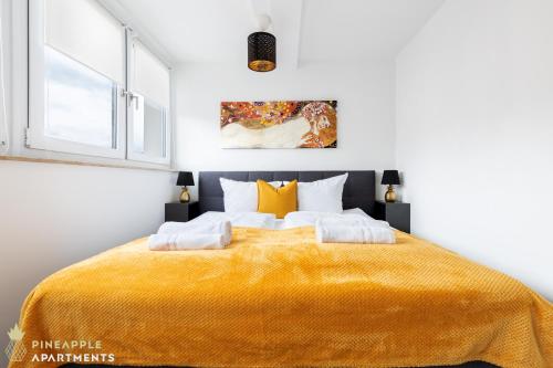 a bedroom with a large bed with a yellow blanket at Pineapple Apartments Dresden Zwinger VI - 98 qm - 1x free parking in Dresden